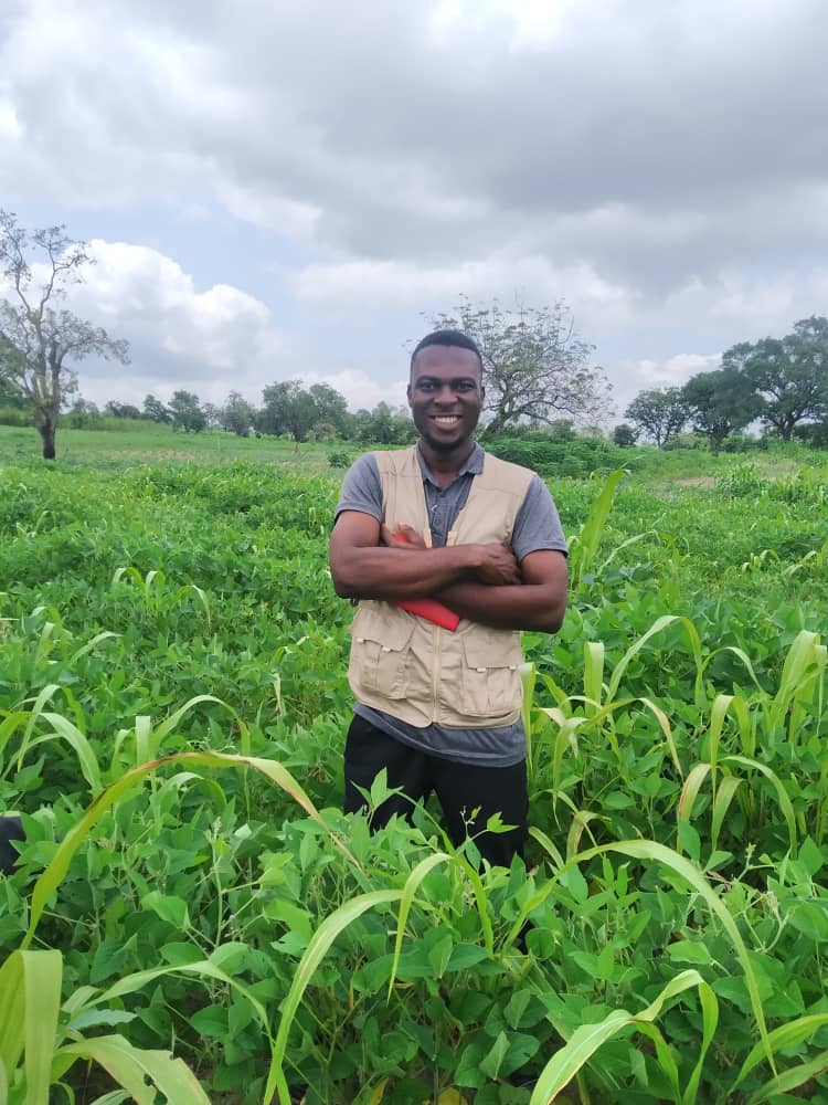 Emmy standing in a soybean field, arms crossed, wearing a field vest
